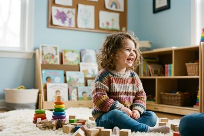 Jeune fille en maternelle souriante dans une salle de jeux lumineuse