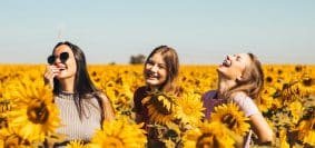3 femmes heureuses dans un champ de tournesol